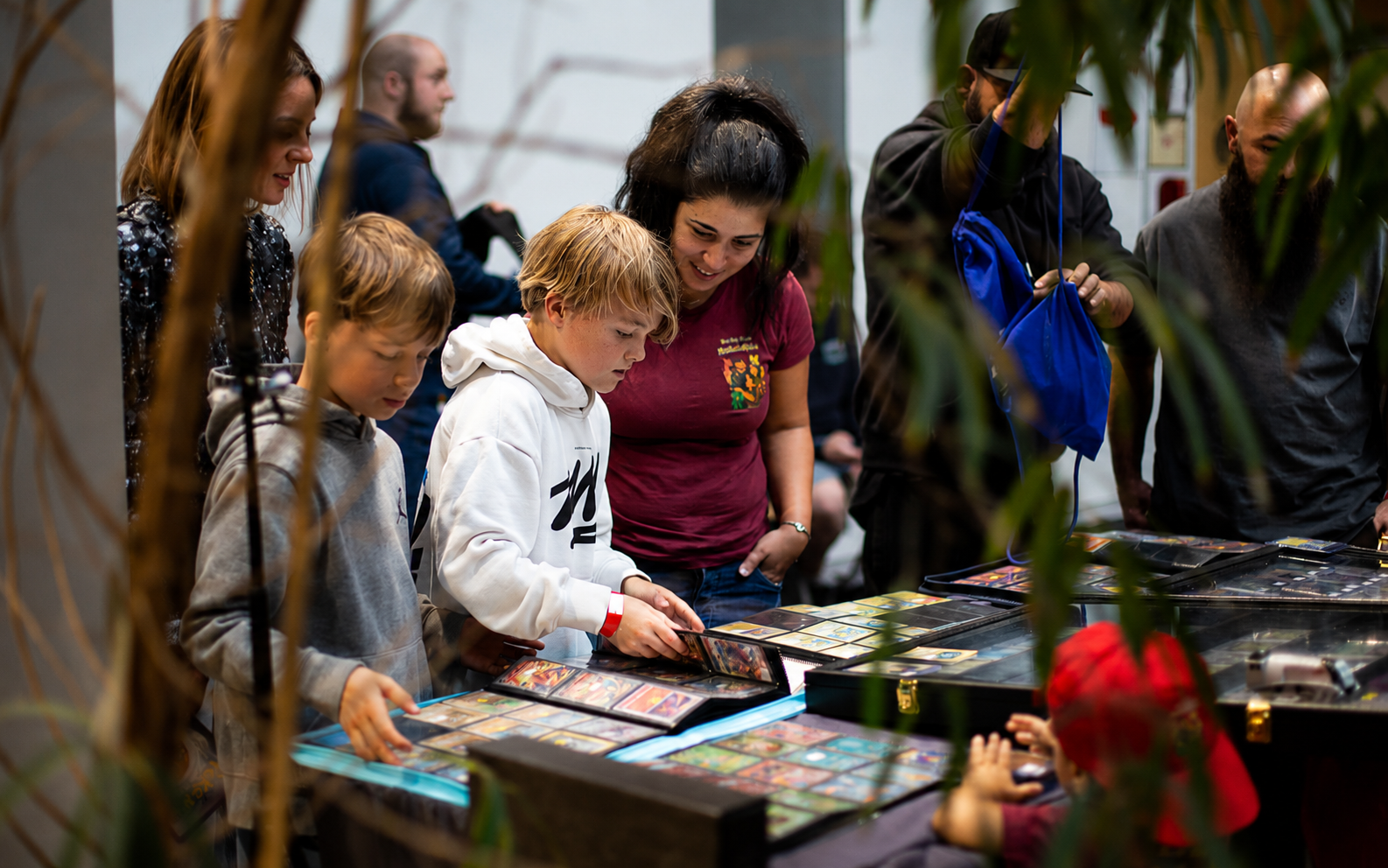 Orbit Card Show community with collectors and families browsing Pokémon cards together
